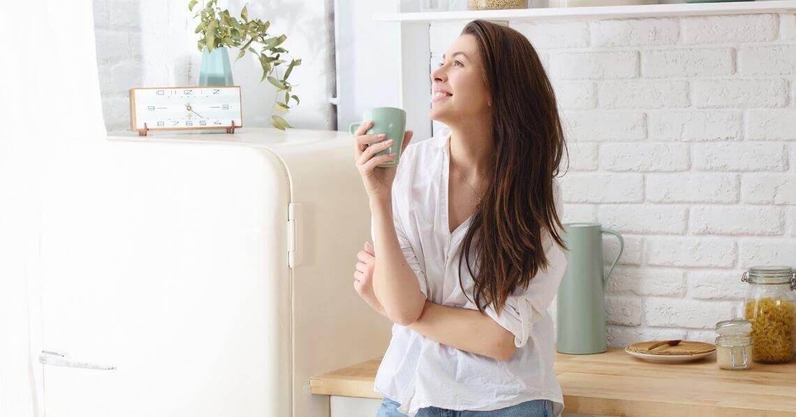 Happy young woman smiling in the kitchen