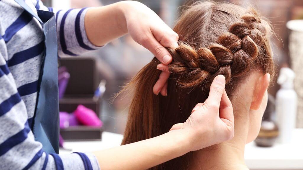 A woman getting her hair braided