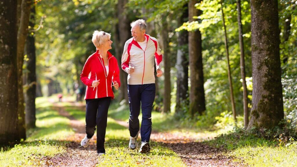 a man and a woman jogging in a forest