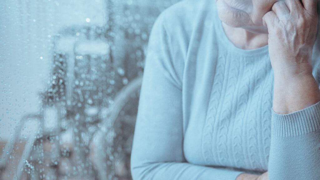 a sad woman by the window on a rainy day