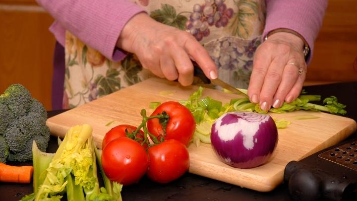 Woman slicing vegetables in the kitchen