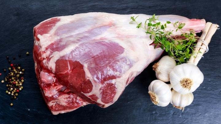 Raw lamb leg with herbs and garlic