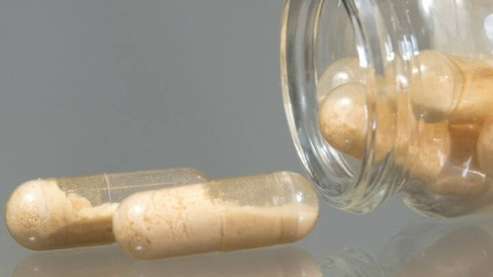 Probiotic capsules next to glass bottle