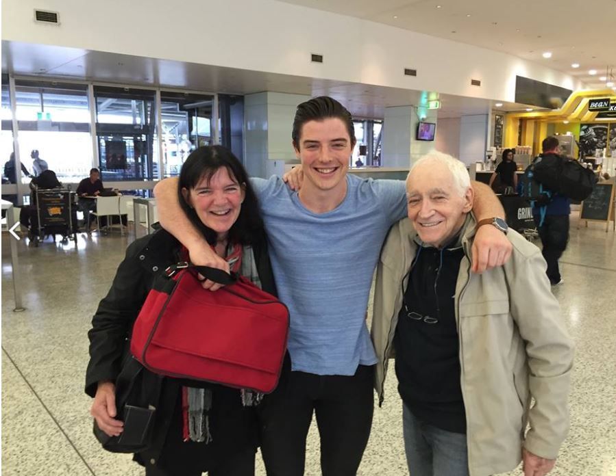 Man with arms around his two elderly parents