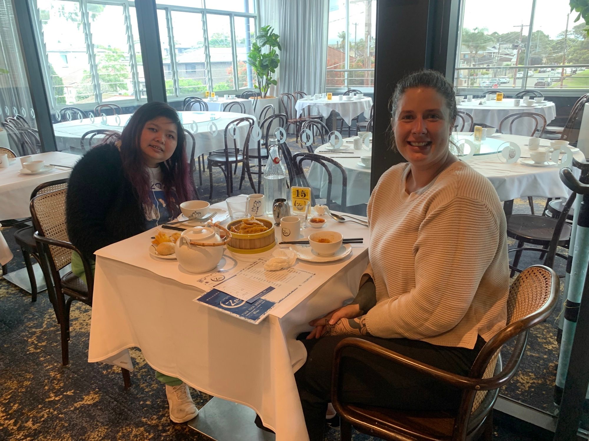 Two women sitting in a restaurant enjoying yum cha