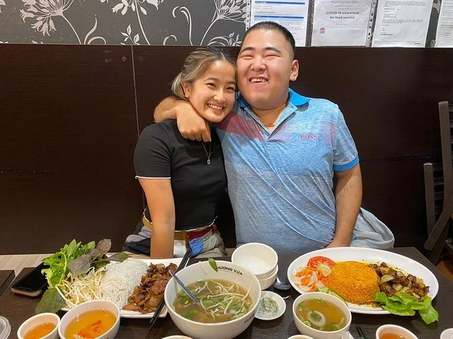 A support worker and participant sharing a big meal