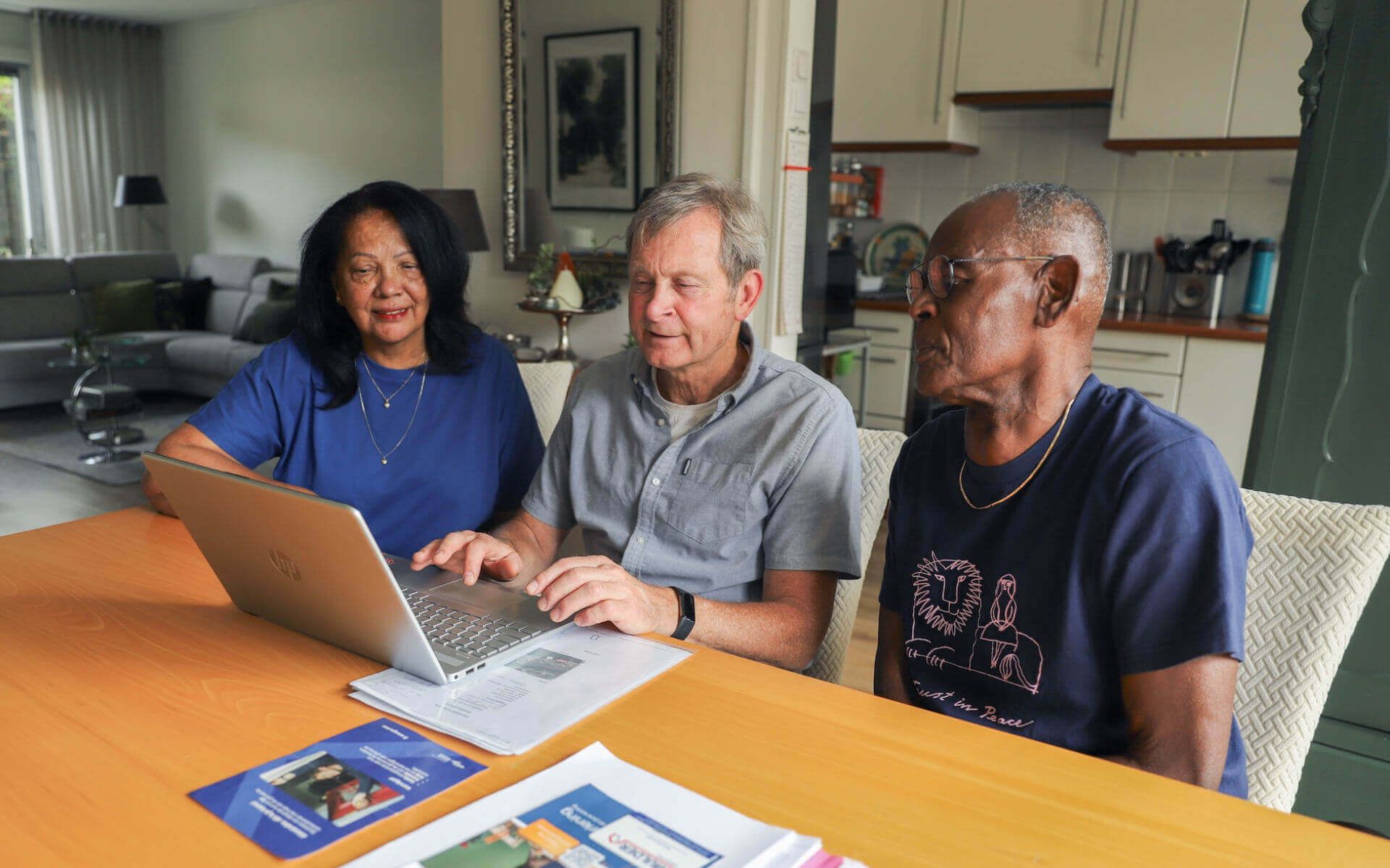 Drie bewoners bekijken samen woninginformatie op een laptop