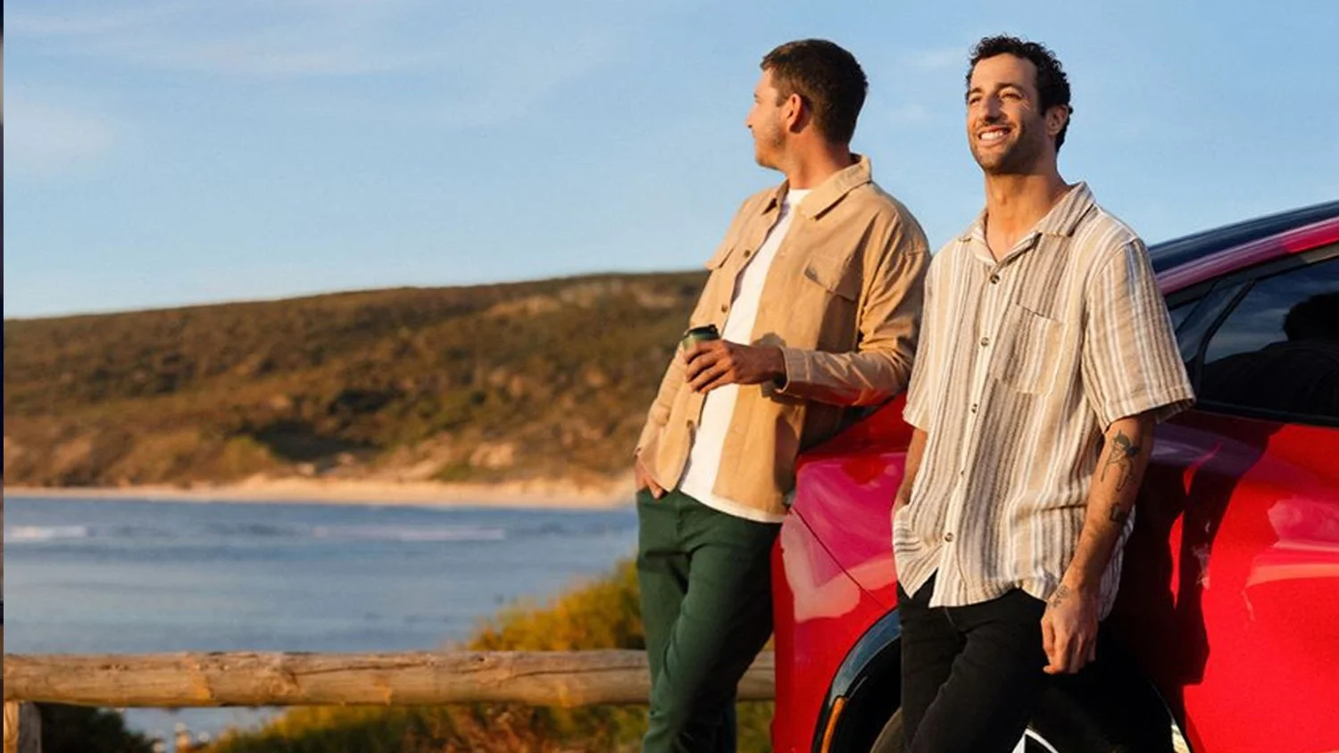 Daniel Ricciardo and a friend beside a red car on the Western Australian coast