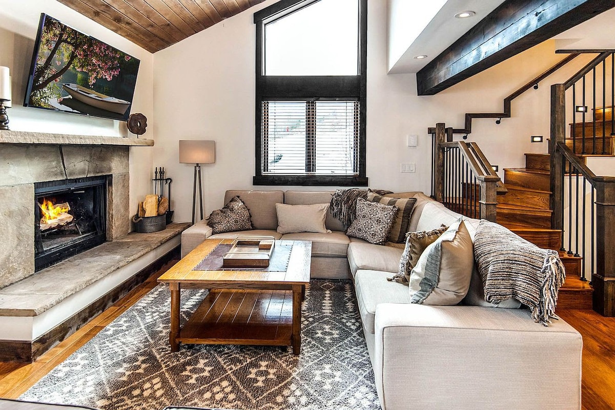 Modern living room shown with wood tones and cream sectional sofa