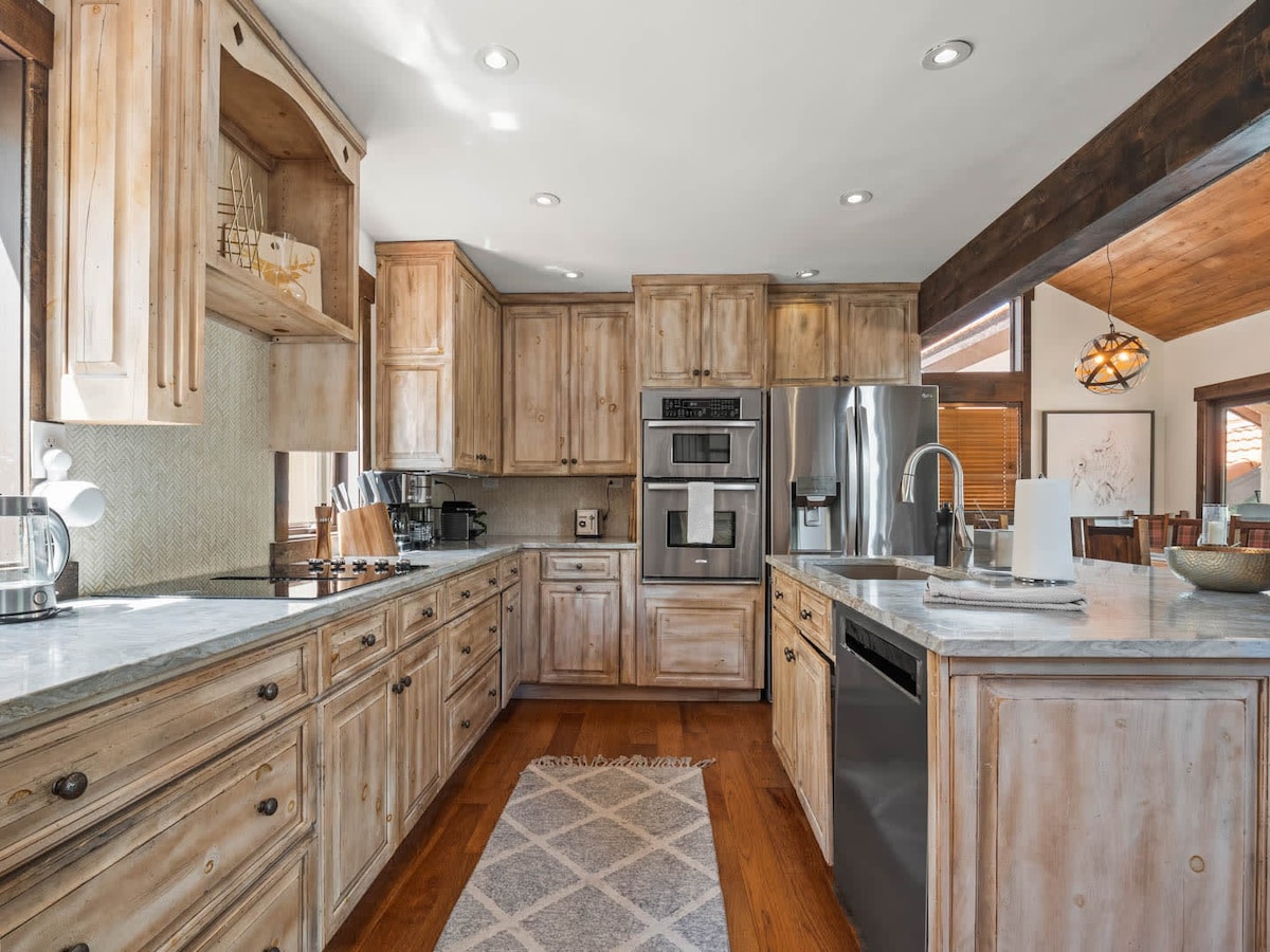 Kitchen shown with birch stained wood cabinets with island on right side