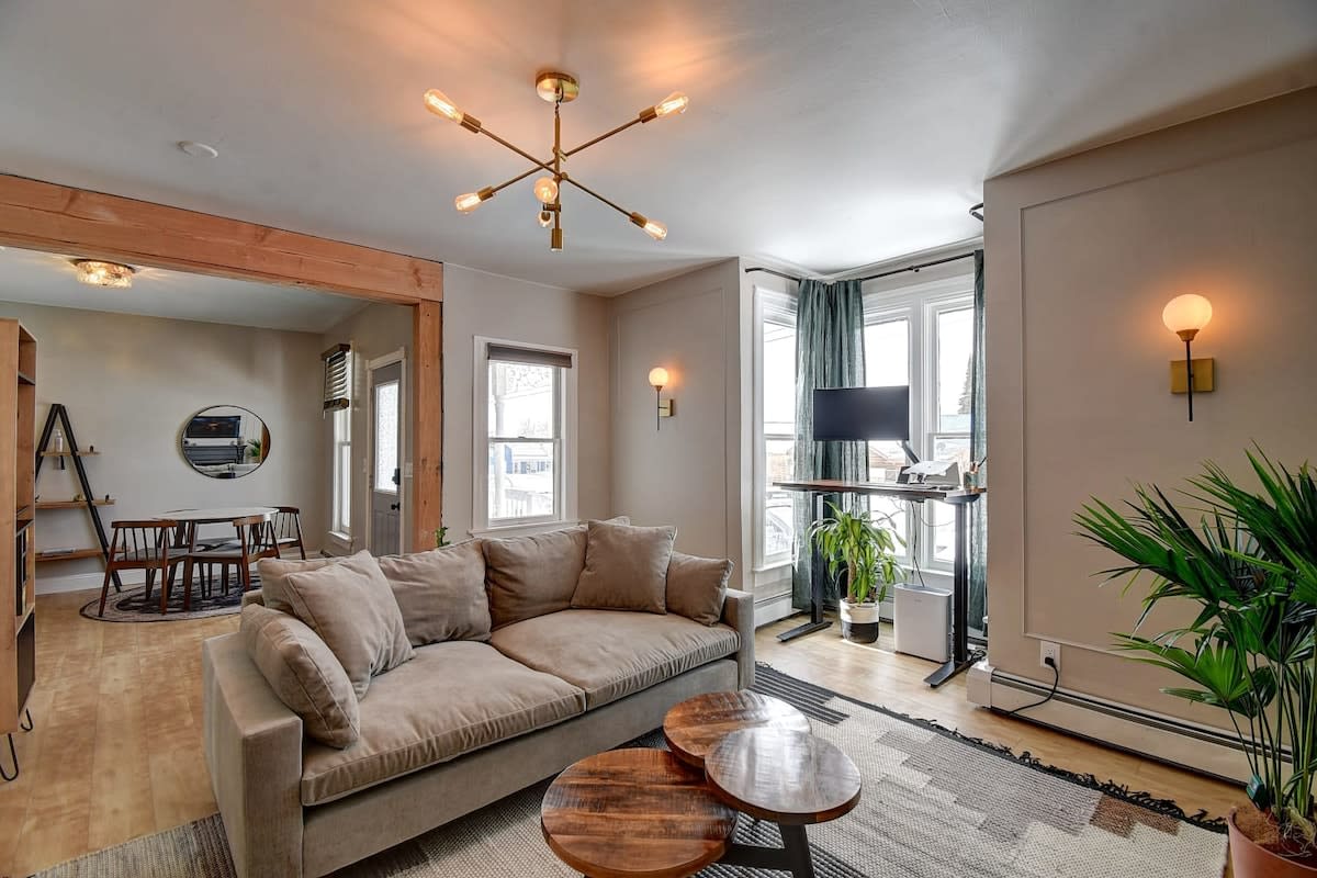 modern living room with light brown sofa in the middle and spoke light fixture above