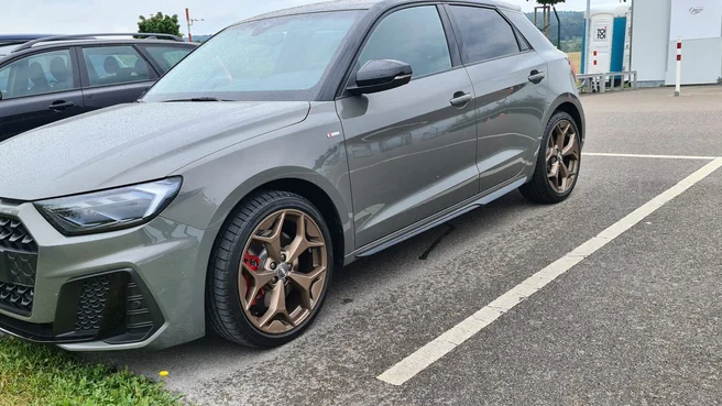Moderner grauer Audi A1 Sport Fahrschulwagen vor urbanem Hintergrund bei Sonnenuntergang