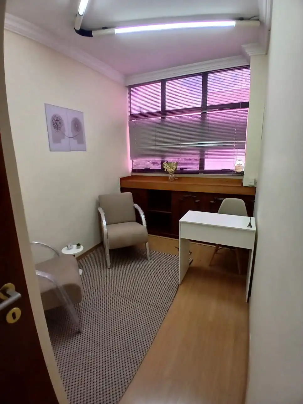 Consultório da ClínCare com mesa e poltronas