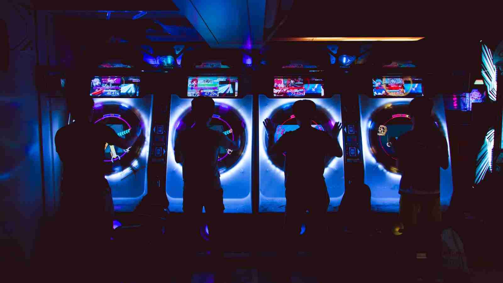 four people playing arcade game