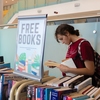 A student browses through free books provided by the library at the NSCC Ivany Campus. Instead of discarding them, the books are offered to staff and students for free before being donated, contributing to waste reduction efforts.