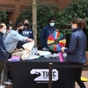 Students running an EarthFest station with a prize wheel, handing out a reusable-bag.