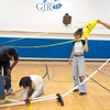 Courtney Knight, a volunteer with Compass at Cornell, works with students, staff and other volunteers at the George Junior Republic High School