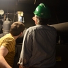 Michigan State University facilities employees observe a gauge in a boiler room while participating in a Spartan Treasure Hunt.