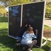 American University student signs chalkboard commitment wall to fight climate change.