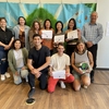 Graduating interns from the USC Office of Sustainability pose with their certificates of appreciation in front of the mural in the campus Sustainability Hub.