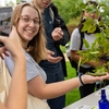 A student has their picture taken while holding a caterpillar at a biodiversity event with The Caterpillar Lab during Brandeis' Year of Climate Action