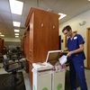 Max, a cosmetology student at Johnson County Community College, uses the campus' Green Circle bin to dispose of cut hair for composting.