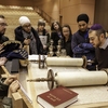 University of Calgary students gather round a sacred Torah scroll at the Beth Tzedec Synagogue in Calgary during the Kaleidoscope Project.