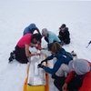 Abby Holt (l) securing a glacier core for climate change research