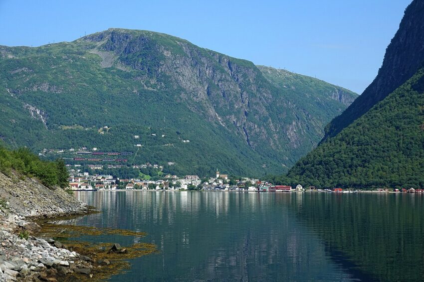 🏔️🌊 Høyanger – Fjordens Perle 🌊🏔️ Høyanger byr på en fantastisk utsikt der byen speiler seg i fjorden, omgitt av majestetiske fjell. Dette bildet viser det idylliske samfunnet som er kjent for sin historie, sine naturopplevelser og nærheten til Gaularfjellet og Nasjonal Turistveg. Nyt denne fredelige utsikten fra fjorden, og opplev den unike kombinasjonen av industrihistorie og vakker natur som Høyanger har å tilby. Foto: Bjørn Christian Tørrissen, CC BY-SA 4.0 https://creativecommons.org/licenses/by-sa/4.0 hoeyanger-skyline-fjord-fjell Høyanger skyline – Fjord, Fjell og Historie Høyanger, Høianger, Høyangr, Høyangsfjord, Høyangerfjorden, Høyanger Vestland, Høyanger kommune, Nasjonal Turistveg Gaularfjellet