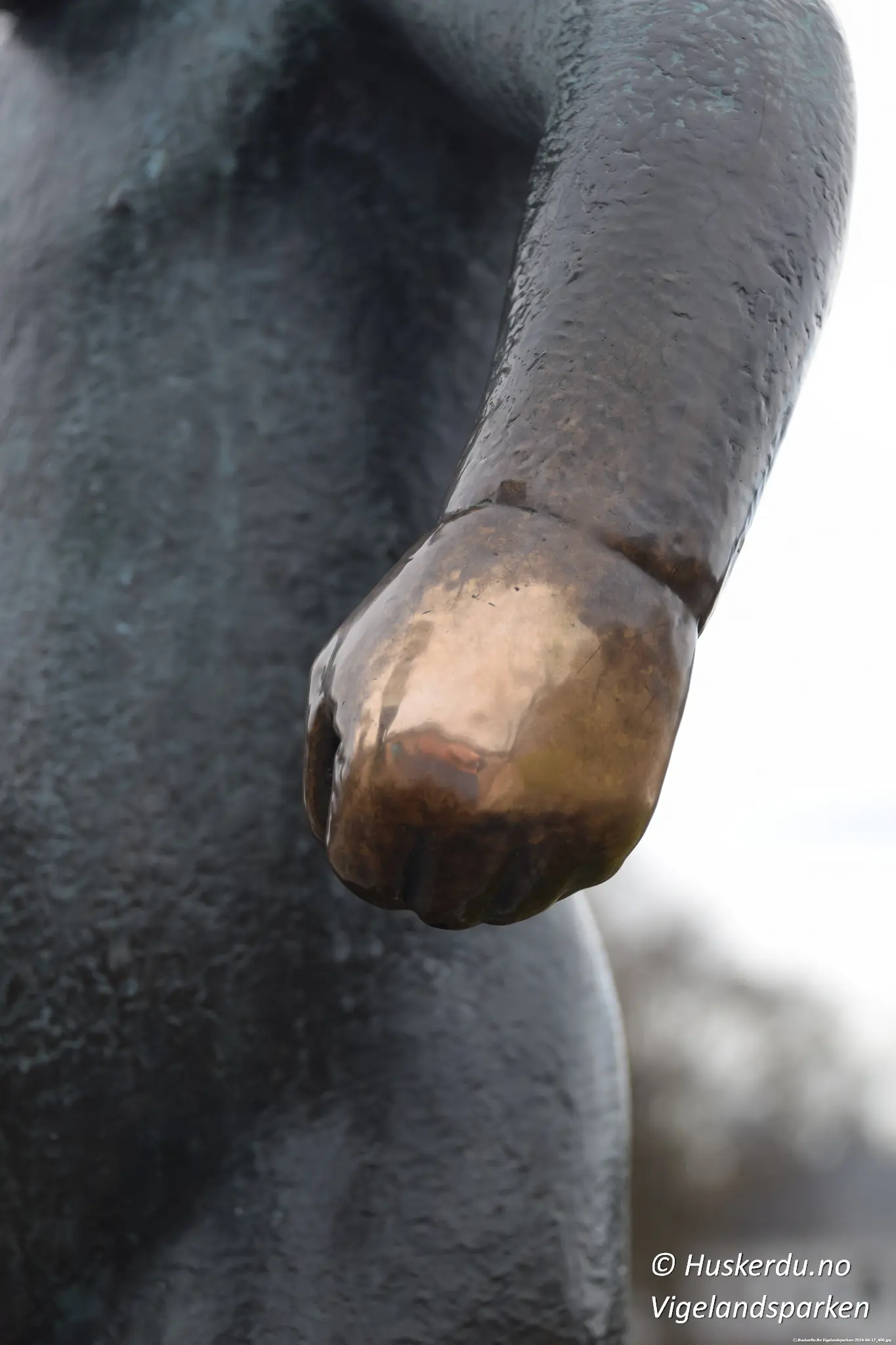 Sinnataggen – En av Norges mest kjente skulpturer Sinnataggen er en ikonisk bronsestatue i Vigelandsparken i Oslo, skapt av Gustav Vigeland. Skulpturen viser en liten gutt med et bestemt og sint uttrykk, kjent for å symbolisere barnets følelser og trass. Figuren er blitt et av de mest populære motivene i parken og et yndet fotosted for turister fra hele verden. Detaljbilder viser hånden og foten til Sinnataggen, som har blitt skåret av flere ganger gjennom historien, men alltid restaurert til sin opprinnelige form. Skinnende partier på statuen avslører hvor tusenvis av besøkende har berørt den i årenes løp, spesielt hånden, som er blitt et symbol på lykke. Sinnataggen står som en sterk representasjon av menneskelige følelser og en viktig del av Vigelands livsverk. Foto: © Huskerdu.no