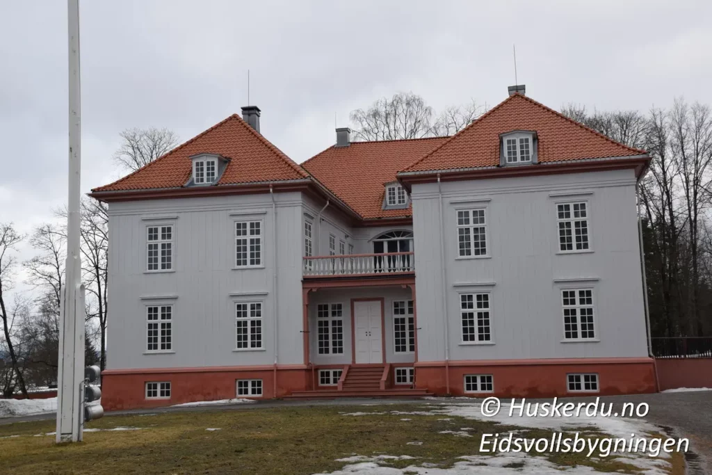 🏛️🇳🇴 Eidsvollsbygningen – Norges Grunnlovs Vugge 🇳🇴🏛️ Eidsvollsbygningen er et av Norges viktigste historiske monumenter. Det var her Grunnloven ble utformet og vedtatt 17. mai 1814. Bygningen, omgitt av vakre omgivelser, gir besøkende en unik innsikt i landets demokratiske historie. På området finner du også en statue av Henrik Wergeland, en av Norges fremste diktere og forkjempere for frihet. Opplev historien på nært hold og gå gjennom de velbevarte rommene der nasjonens fremtid ble formet. Foto: © Huskerdu.no, Eidsvollsbygningen – Historie og Frihetens Symbol Søkeord: Eidsvollsbygningen, Eidsvoll bygning, Henrik Wergeland statue, Norges Grunnlov, Eidsvoll museum, norsk historie, 1814, grunnlovens hus, Eidsvollsbygningen museum, Eidsvoll plass, nasjonalmonument Norge