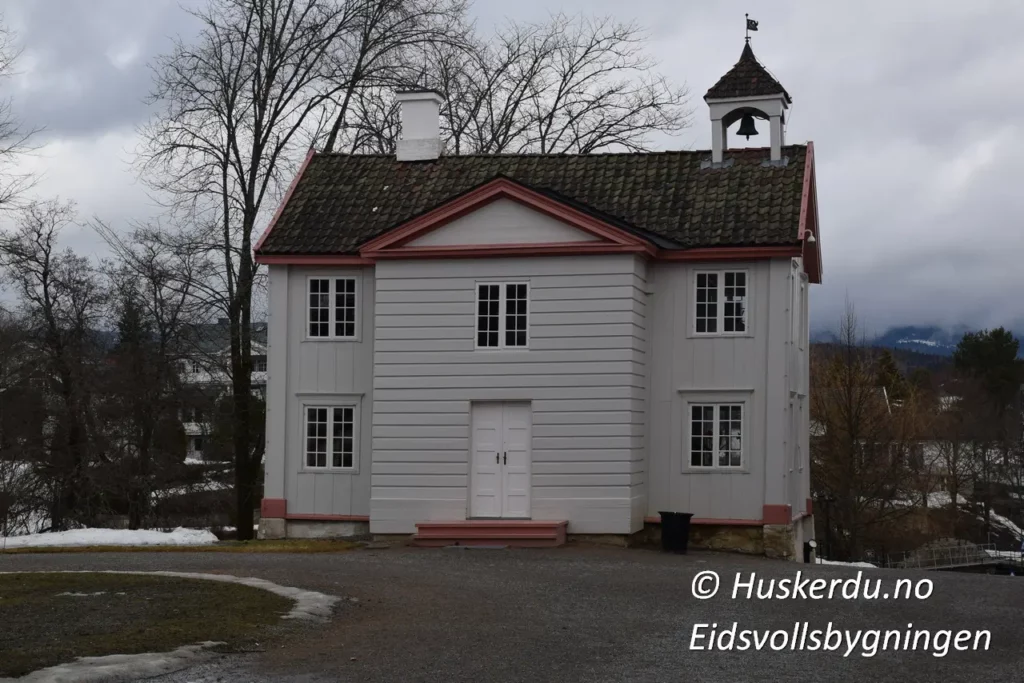 🏛️🇳🇴 Eidsvollsbygningen – Norges Grunnlovs Vugge 🇳🇴🏛️ Eidsvollsbygningen er et av Norges viktigste historiske monumenter. Det var her Grunnloven ble utformet og vedtatt 17. mai 1814. Bygningen, omgitt av vakre omgivelser, gir besøkende en unik innsikt i landets demokratiske historie. På området finner du også en statue av Henrik Wergeland, en av Norges fremste diktere og forkjempere for frihet. Opplev historien på nært hold og gå gjennom de velbevarte rommene der nasjonens fremtid ble formet. Foto: © Huskerdu.no, Eidsvollsbygningen – Historie og Frihetens Symbol Søkeord: Eidsvollsbygningen, Eidsvoll bygning, Henrik Wergeland statue, Norges Grunnlov, Eidsvoll museum, norsk historie, 1814, grunnlovens hus, Eidsvollsbygningen museum, Eidsvoll plass, nasjonalmonument Norge