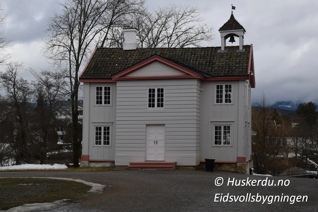 🏛️🇳🇴 Eidsvollsbygningen – Norges Grunnlovs Vugge 🇳🇴🏛️ Eidsvollsbygningen er et av Norges viktigste historiske monumenter. Det var her Grunnloven ble utformet og vedtatt 17. mai 1814. Bygningen, omgitt av vakre omgivelser, gir besøkende en unik innsikt i landets demokratiske historie. På området finner du også en statue av Henrik Wergeland, en av Norges fremste diktere og forkjempere for frihet. Opplev historien på nært hold og gå gjennom de velbevarte rommene der nasjonens fremtid ble formet. Foto: © Huskerdu.no, Eidsvollsbygningen – Historie og Frihetens Symbol Søkeord: Eidsvollsbygningen, Eidsvoll bygning, Henrik Wergeland statue, Norges Grunnlov, Eidsvoll museum, norsk historie, 1814, grunnlovens hus, Eidsvollsbygningen museum, Eidsvoll plass, nasjonalmonument Norge