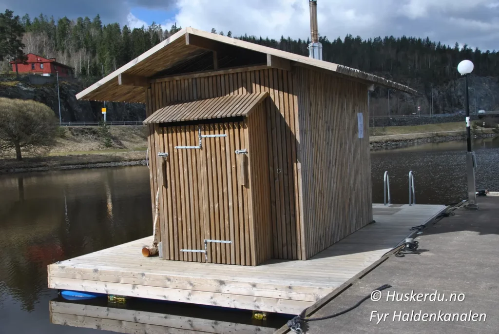 Fyr Haldenkanalen 🧖♂️🧖♀️🌊 Opplev den flytende badstuen ved Haldenkanalen i Ørje – et perfekt sted for avslapning og velvære i naturskjønne omgivelser. Med moderne design i treverk og en rolig atmosfære, gir denne badstuen deg muligheten til å kombinere varme økter med forfriskende bad i kanalen. Enten du besøker stedet for en rolig stund alene eller med venner, gir denne unike opplevelsen et avbrekk fra hverdagen. Nyt utsikten, den varme dampen og roen ved vannet. 🌲🔥 Foto: © Huskerdu.no