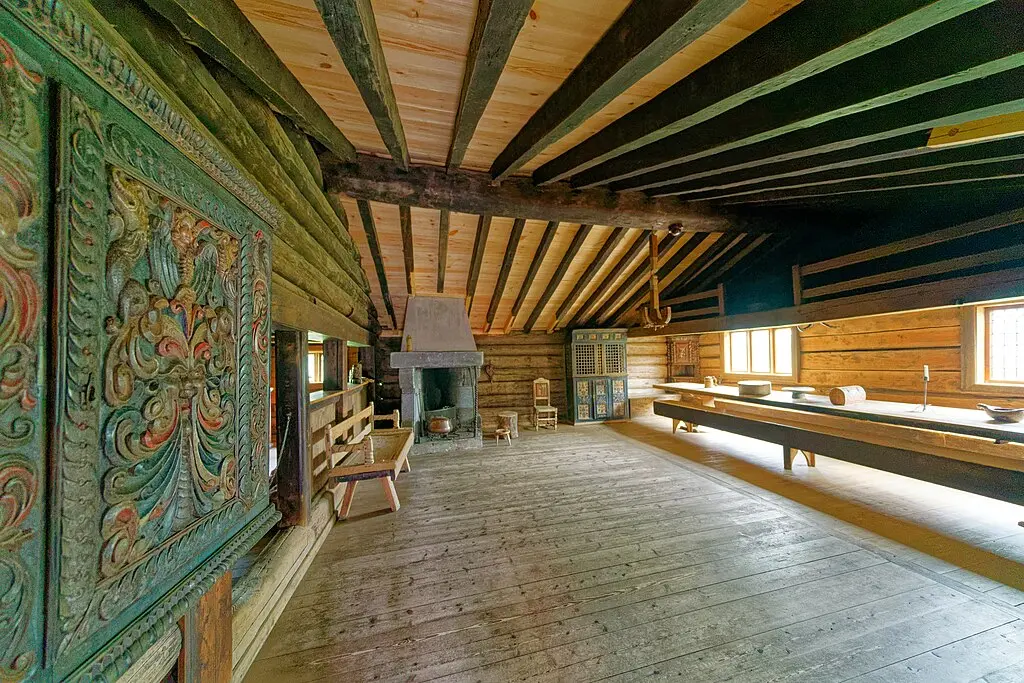 🏚️✨ Historisk Rom på Maihaugen ✨🏚️ Utforsk historien på Maihaugen, et av Norges største friluftsmuseer. Dette bildet viser et vakkert innredet rom med tradisjonelle treskjæringer og gamle møbler, som gir et innblikk i livet på norske gårder i tidligere tider. Maihaugen på Lillehammer er perfekt for å oppleve norsk kulturarv med autentiske bygninger og utstillinger fra forskjellige tidsepoker. Museet byr på både innendørs utstillinger og et friluftsområde med historiske hus. Foto: Holger Uwe Schmitt, CC BY-SA 4.0 Lisens: CC BY-SA 4.0 (Holger Uwe Schmitt) https://creativecommons.org/licenses/by-sa/4.0 maihaugen-lillehammer-historisk-rom Maihaugen på Lillehammer – Historisk Rom og Norsk Kulturarv Maihaugen, Maihaugen Museum, Lillehammer museum, historisk museum Lillehammer, norsk kulturarv, friluftsmuseum Lillehammer, Maihaugen interiør, Maihaugen treskjæring, Maihaugen historiske hus