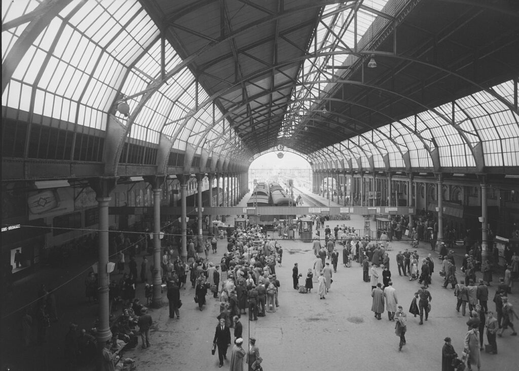 🚉✨ Østbanehallen før tragedien ✨🚉 Dette historiske bildet fra 1956 viser Østbanehallen, en livlig møteplass i hjertet av Oslo. Hallens ikoniske glasstak og åpne plattformer var vitne til utallige reisende gjennom tidene. Mange år senere ble denne historiske bygningen et åsted for en tragisk hendelse, da en bombeeksplosjon rystet hallen i 1982. Bildet minner oss om stedets lange historie og kontrasten mellom en travel hverdag og senere tragiske hendelser. Foto: Ukjent fotograf, offentlig eiendom. Lisens: Offentlig eiendom (Public Domain) https://commons.wikimedia.org/wiki/File:%C3%98stbanen_-_no-nb_digifoto_20150219_00237_NB_MIT_FNR_16515.jpg ostbanehallen-oslo-historisk-1956 Østbanehallen – Fra Liv til Tragedie Østbanehallen, Østbanen, Oslo Sentralstasjon, Oslo S, Østbanestasjonen, Østbanehallen eksplosjon, Østbanehallen historie, Oslo togstasjon, Østbanehallens tragedie, Østbanehallen 1982, Østbanehallen 1956, Oslo eksplosjon