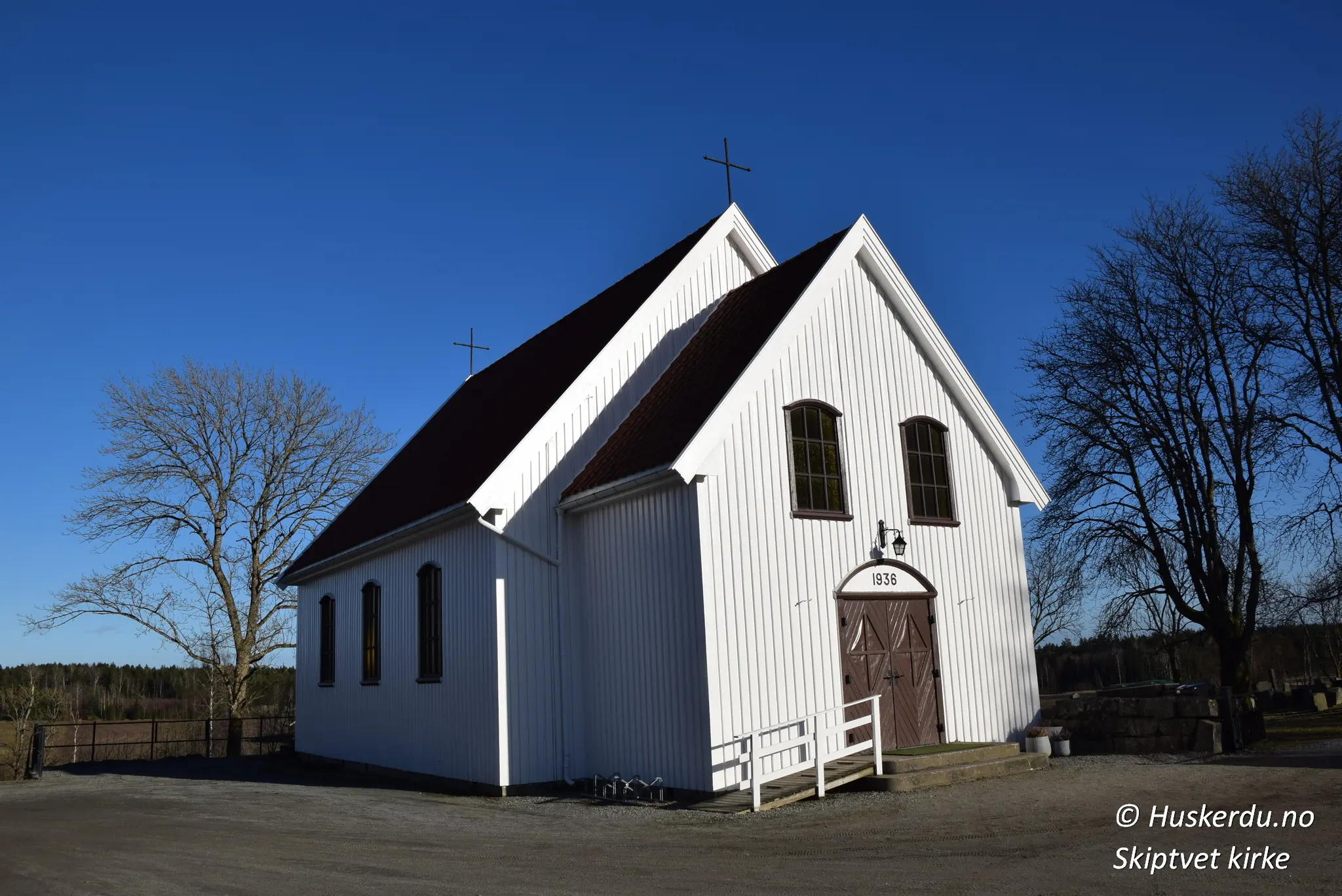 ⛪🌿 Skiptvet Kapell – En Stille Hvileplass 🌿⛪ Skiptvet kapell, bygget i 1936, er et enkelt og vakkert bindingsverkskapell som ligger ved siden av Skiptvet kirke. Kapellet brukes til mindre seremonier som dåp, vielser og minnestunder. Den hvitmalte fasaden og det rolige miljøet skaper en stemningsfull ramme for både høytid og ettertanke. Kapellet er en viktig del av kirkens historiske og kulturelle helhet. Foto: Huskerdu.no skiptvet-kapell-1936-seremonibygg Skiptvet Kapell – Hvitt Bindingsverkskapell fra 1936 Skiptvet kapell, Skiptvet kirke, Østfold kapell, seremonibygg Skiptvet, gravkapell Skiptvet, Skiptvet kirke kapell, 1936 kapell, Østfold kirker, bindingsverkskapell