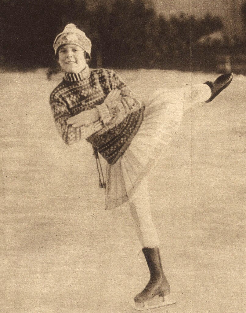 ⛸❄️ Sonja Henie som ung skøytestjerne ❄️⛸ Dette ikoniske bildet fra 1927 viser Sonja Henie, kun fjorten år gammel, i sitt ess på isen. Henie hadde allerede begynt å gjøre seg bemerket som en fremragende kunstløper, og 1927 ble året hun vant sitt første verdensmesterskap. Med sin eleganse og talent banet hun vei for en av de mest suksessrike karrierene innen kunstløp. Bildet gir et nostalgisk innblikk i Henies tidlige år som skøyteikon. Foto: Ukjent forfatter, Illustriertes Sportblatt, Public domain https://commons.wikimedia.org/wiki/File:1927_Sonja_Henie.jpg sonja-henie-1927-skoyteikon Sonja Henie – Ung skøytestjerne i 1927 Sonja Henie, Oslo, kunstløp, Sonja Henie 1927, ung skøyteløper, verdensmesterskap kunstløp, norsk idrettshistorie, skøytestjerne, skøyteikon, Sonja Henie historie, Frogner Stadion, norsk kultur