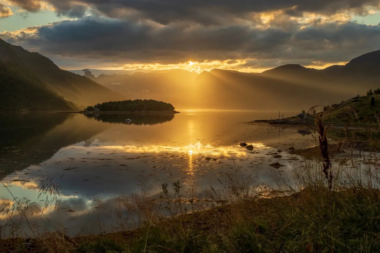 Kveldssol over Øksfjorden 🌅 Lav kveldssol bryter gjennom skyene over Øksfjorden i Øksfjordbotn, ytterst i Loppa kommune. Dette er utsikt mot noen av Finnmarks mest dramatiske fjell og brelandskap, med speilblankt vann og fjern horisont. Bildet er tatt i august, når lyset fortsatt varer sent på kvelden – perfekt for fotografer som vil oppleve naturen i det gyldne nordnorske lyset. Foto: Simo Räsänen, CC BY-SA 4.0 https://creativecommons.org/licenses/by-sa/4.0 https://commons.wikimedia.org/wiki/File:Low_sunlight_at_%C3%98ksfjorden_in_Loppa,_Troms_og_Finnmark,_Norway,_2022_August.jpg kveldssol-over-oksfjorden-i-loppa Kveldssol over Øksfjorden i Øksfjordbotn øksfjord, oksfjord, oksfjordbotn, loppa, øksfjorden, midnattssol, fjordlandskap, fjell og hav Loppa kommune