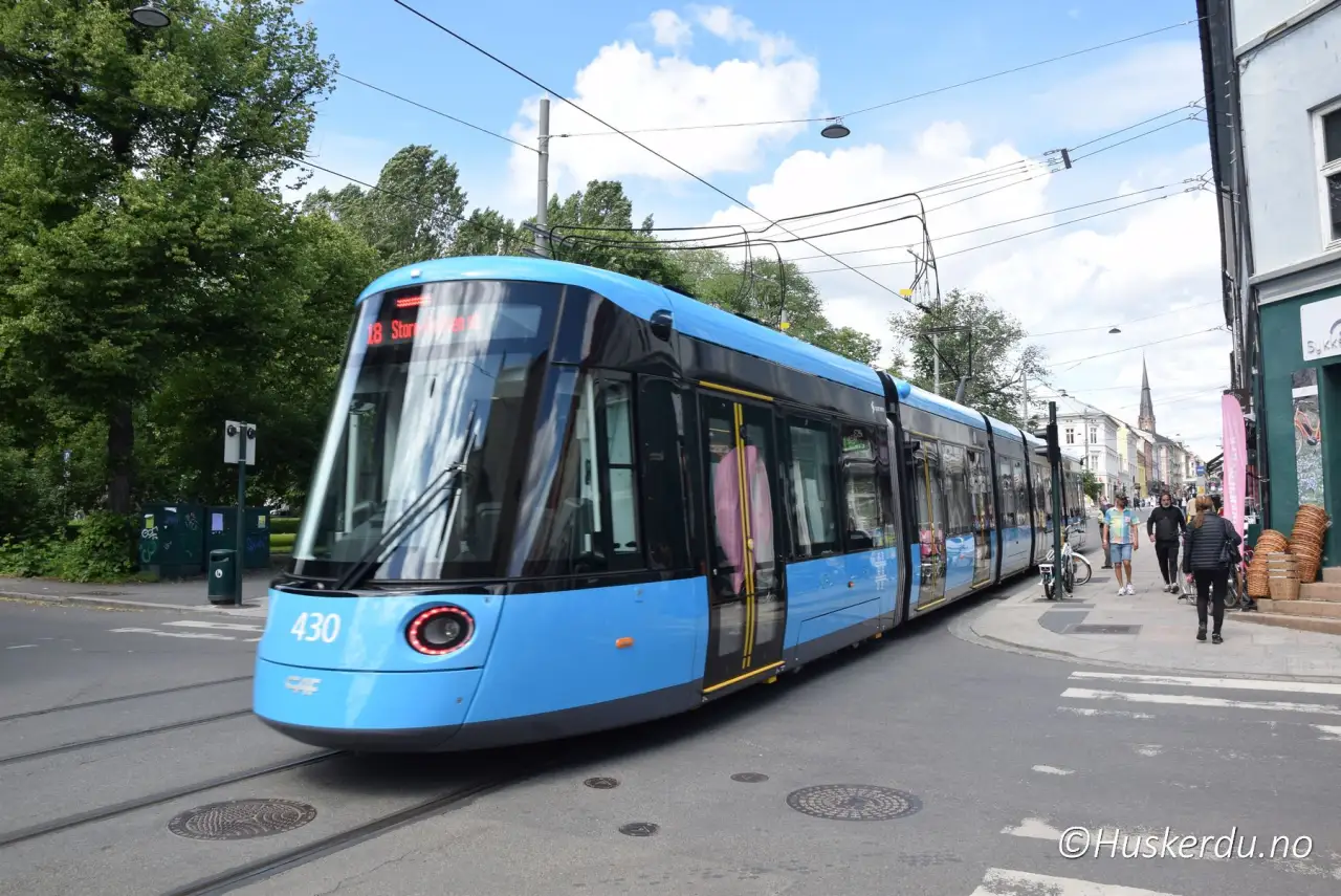Trikk i bybildet 🚋 En moderne blå trikk kjører gjennom Oslos gater og binder sammen sentrum med byens mange bydeler. Sporvognen er en viktig del av kollektivtrafikken og gjør det enkelt for både turister og fastboende å komme seg rundt. I bakgrunnen skimtes byliv med butikker, kafeer og karakteristiske bygårder. Foto: © Huskerdu.no Trikk i Oslo sentrum oslo-trikk-07-jun-24_046-huskerdu Trikk i Oslo – moderne sporvogn i bybildet Oslo, Oslo trikk, trikk Oslo, sporvogn Oslo, kollektivtrafikk Oslo, bytransport Oslo, trikken i Oslo, sentrumstrikk Oslo Oslo Kommune