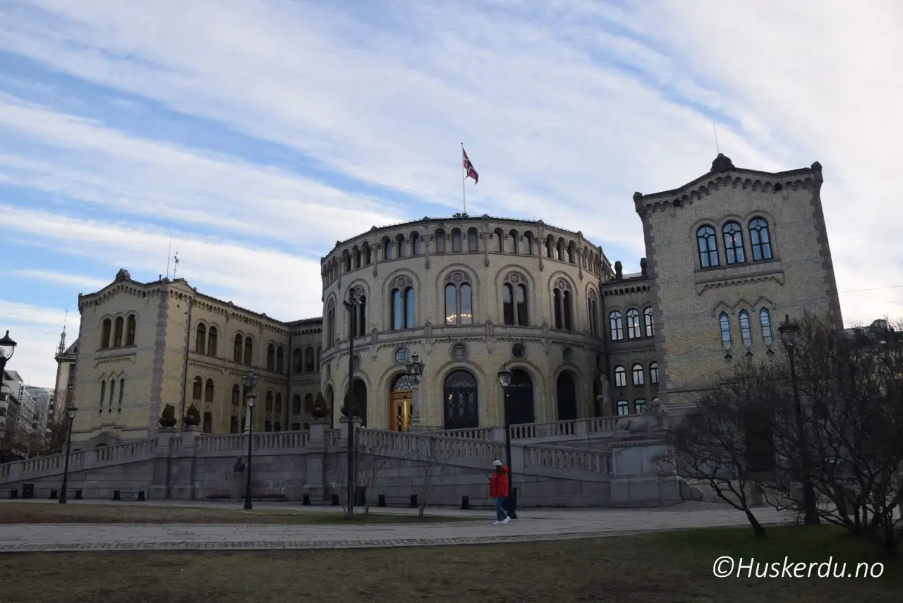 Stortinget i Oslo 🇳🇴 Stortingsbygningen fra 1866 ligger midt på Karl Johans gate og er selve hjertet i norsk demokrati. Den karakteristiske runde salen brukes fortsatt til debatter og avstemninger som former landets politikk. Bygget er et av de mest besøkte i Oslo, og mange turister stopper opp her for å ta bilder eller delta på omvisninger som gir innblikk i norsk historie og samfunnsliv. Foto: © Huskerdu.no stortinget-nr_23-20-12-2024-huskerdu-no Stortinget – Nasjonalforsamlingen i Norge Oslo, Stortinget, Stortinget Oslo, stortingsbygningen, Karl Johans gate, norsk politikk, nasjonalforsamling, Oslo sentrum Oslo Kommune