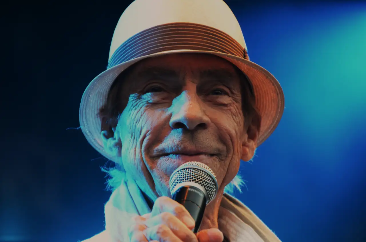 Jahn Teigen med sitt lune smil 🌟 Mot slutten av karrieren møtte publikum en artist som fortsatt ga alt – med varme, humor og takknemlighet. Smilet hans ble et varemerke, og minnene om ham lever videre i sangene som fremdeles samler folk i både glede og vemod. Foto: Bamble kommune, CC BY-SA 2.0 https://creativecommons.org/licenses/by-sa/2.0 https://commons.wikimedia.org/wiki/File:Jahn_Teigen_(5982270403).jpg jahn-teigen-lunt-i-profil-i-Bamble Jahn Teigen – et varmt smil til publikum jahn teigen, jan teigen, optimist, norsk musikk, arv etter jahn teigen, nasjonalskatt, bamble, telemark Bamble kommune