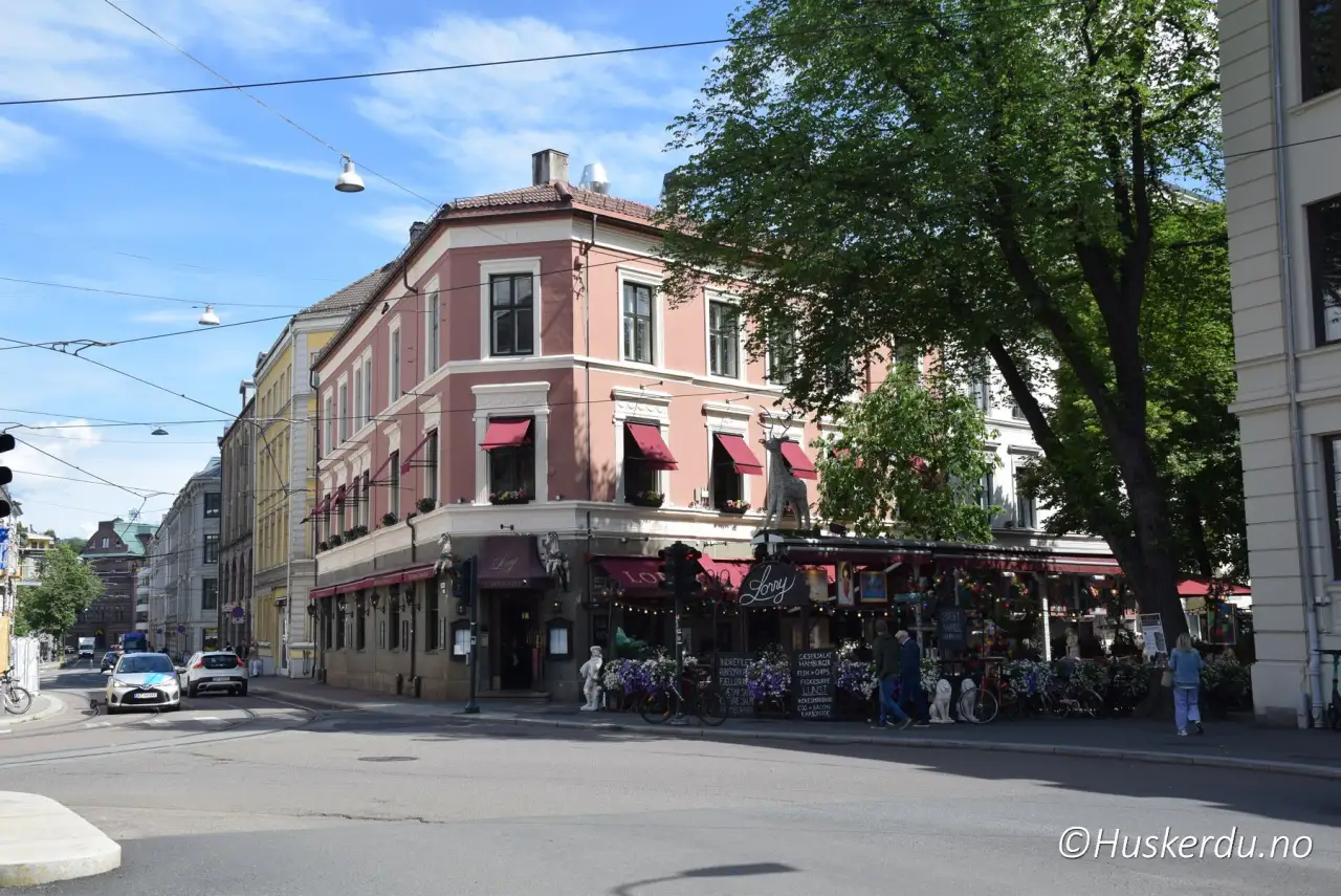 Lorry på Frogner 🍷 Det rosa hjørnehuset på Frogner huser Lorry, en av byens mest kjente møteplasser. Uteserveringen under markiser fylles gjennom hele året, og stedet har lenge vært knyttet til kultur og debatt i hovedstaden. Bygget med sine røde markiser skaper et særpreget bymiljø rett ved Slottsparken. Foto: © Huskerdu.no lorry-07-06-2024-huskerdu Lorry Oslo – Historisk restaurant og møteplass Oslo, Lorry, Lorry Oslo, Frogner, Oslo restauranter, Oslo uteservering, byliv i Oslo, Oslo kultursteder Oslo Kommune