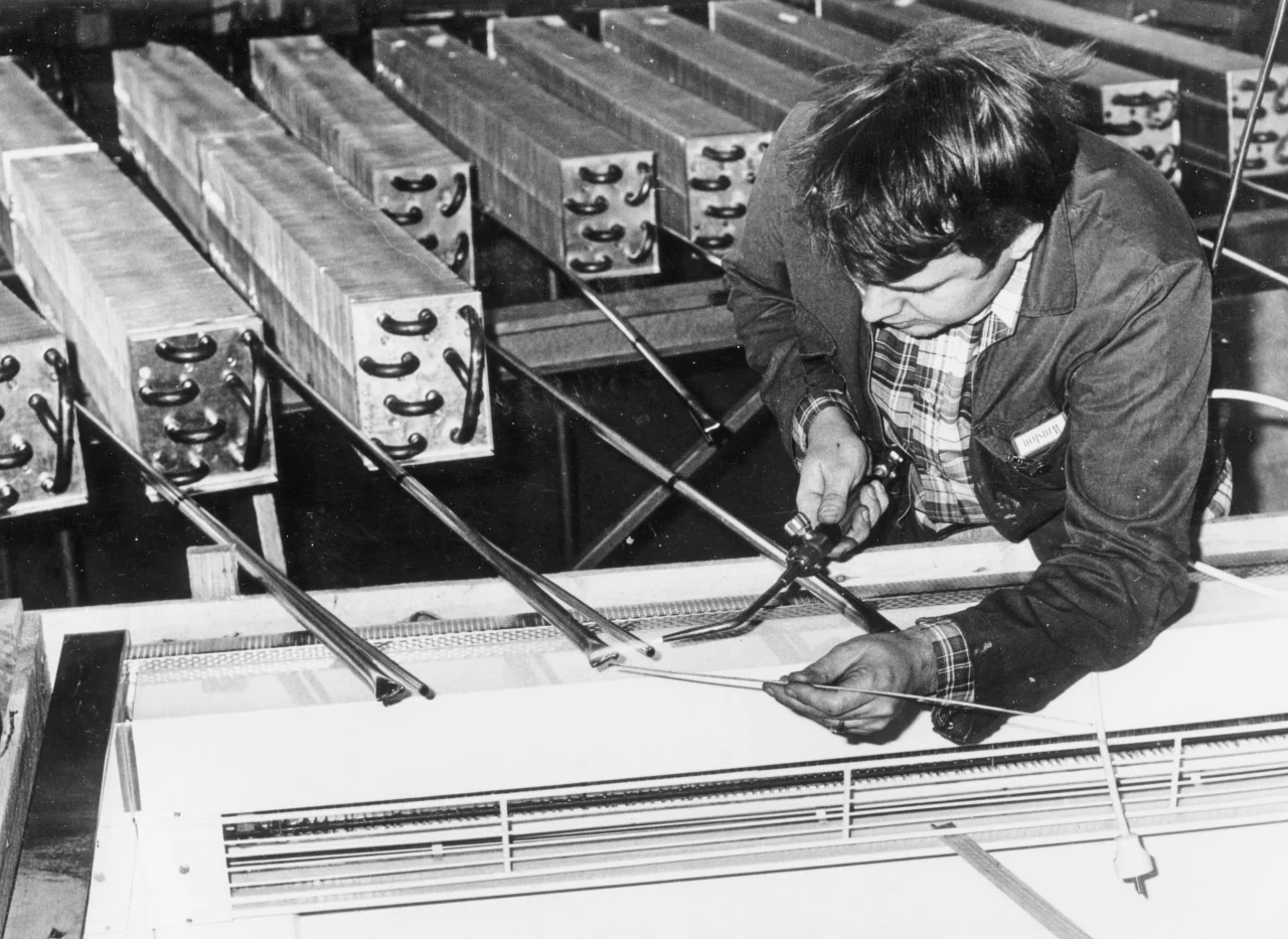 Bjørn Sandbæk lodder kjøleelementer ved Norild på 1970-tallet, med kobberrør og aluminiumsfinner for optimal varmeoverføring