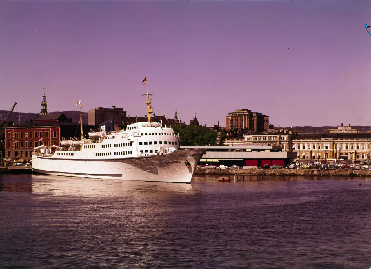 MS Holger Danske ligger ved kai i Oslo havn i 1964 med byens bygninger i bakgrunnen, klar for avgang mot Danmark.