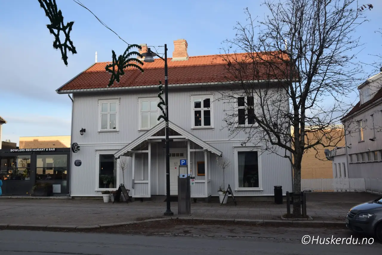 Bevart trehus i Jessheim sentrum med hvitmalt fasade, klassisk inngangsparti og moderne virksomhet i første etasje.