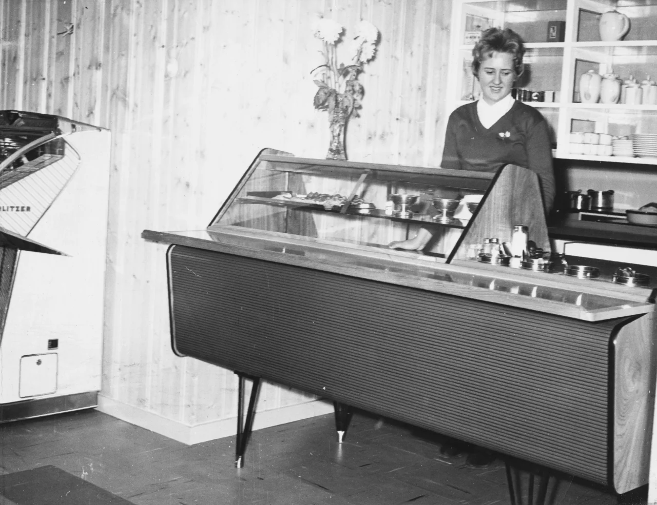 Kalypso kafeteriadisk fra Norild på 1960-tallet med skråstilt glass, kjøling og plass for serveringsutstyr i en kafeteria.