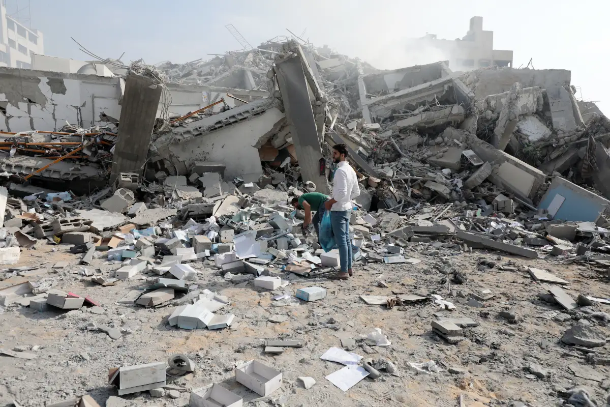 Palestinere leter etter eiendeler i ruinene av en boligblokk i Gaza.