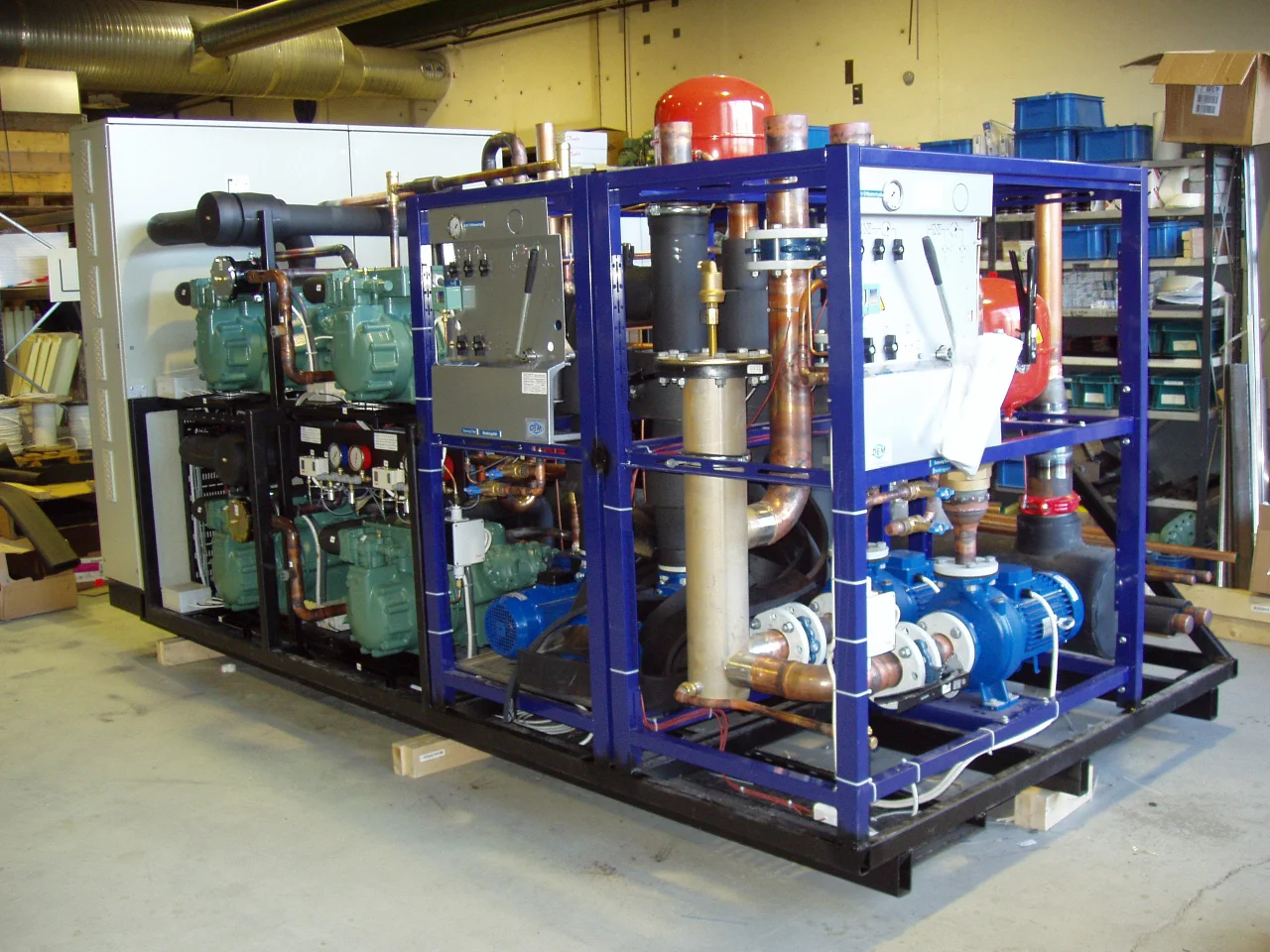 Stort CO₂-system bygges ved Norilds fabrikk med rør, ventiler og kompressorer i stålramme.