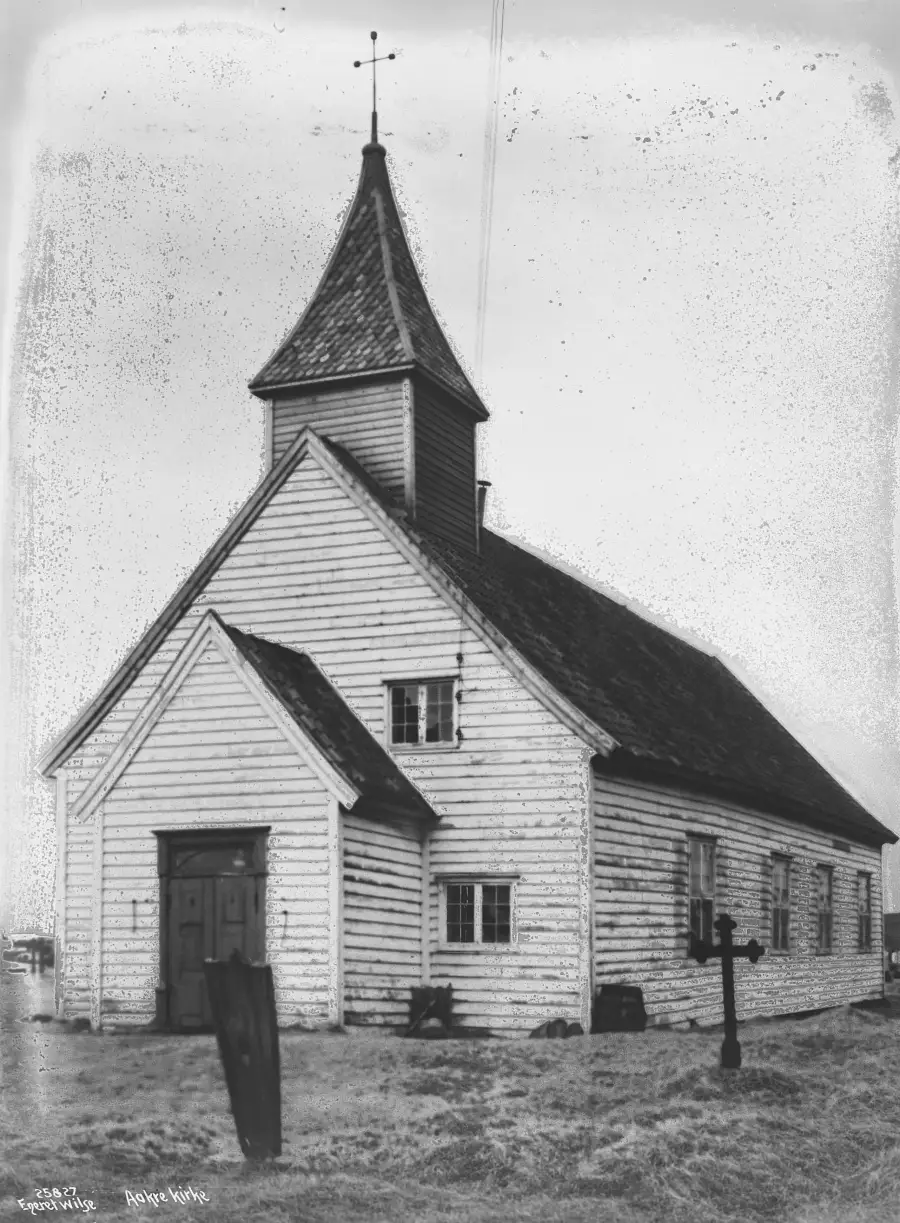 Åkra gamle kirke sett fra fronten i 1925 med tårn og trekonstruksjon.